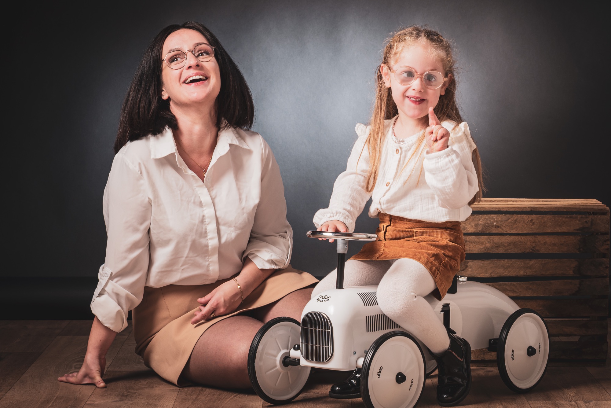 Séance photo famille avec mère et fille en studio, sourires et complicité.