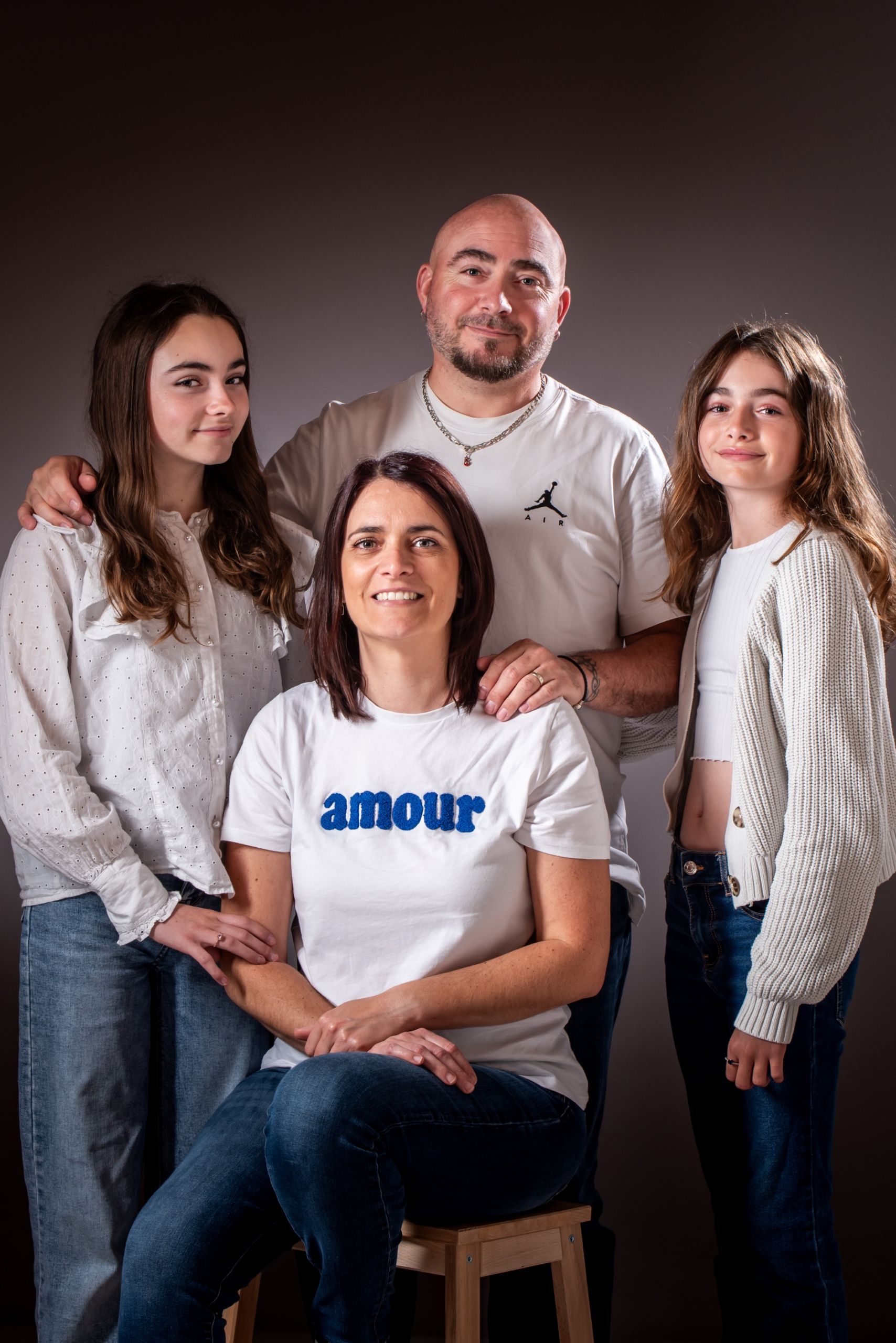 Séance photo famille chaleureuse en studio avec quatre membres.