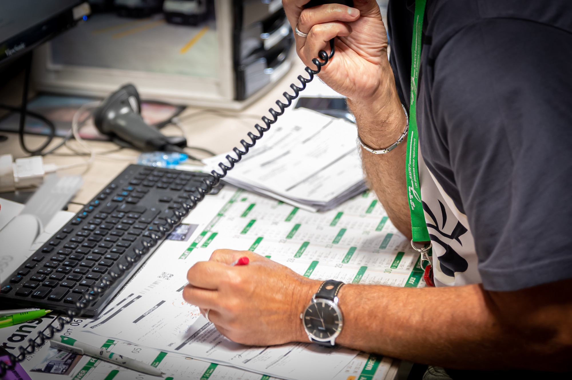Main d'un professionnel au téléphone avec un ordinateur