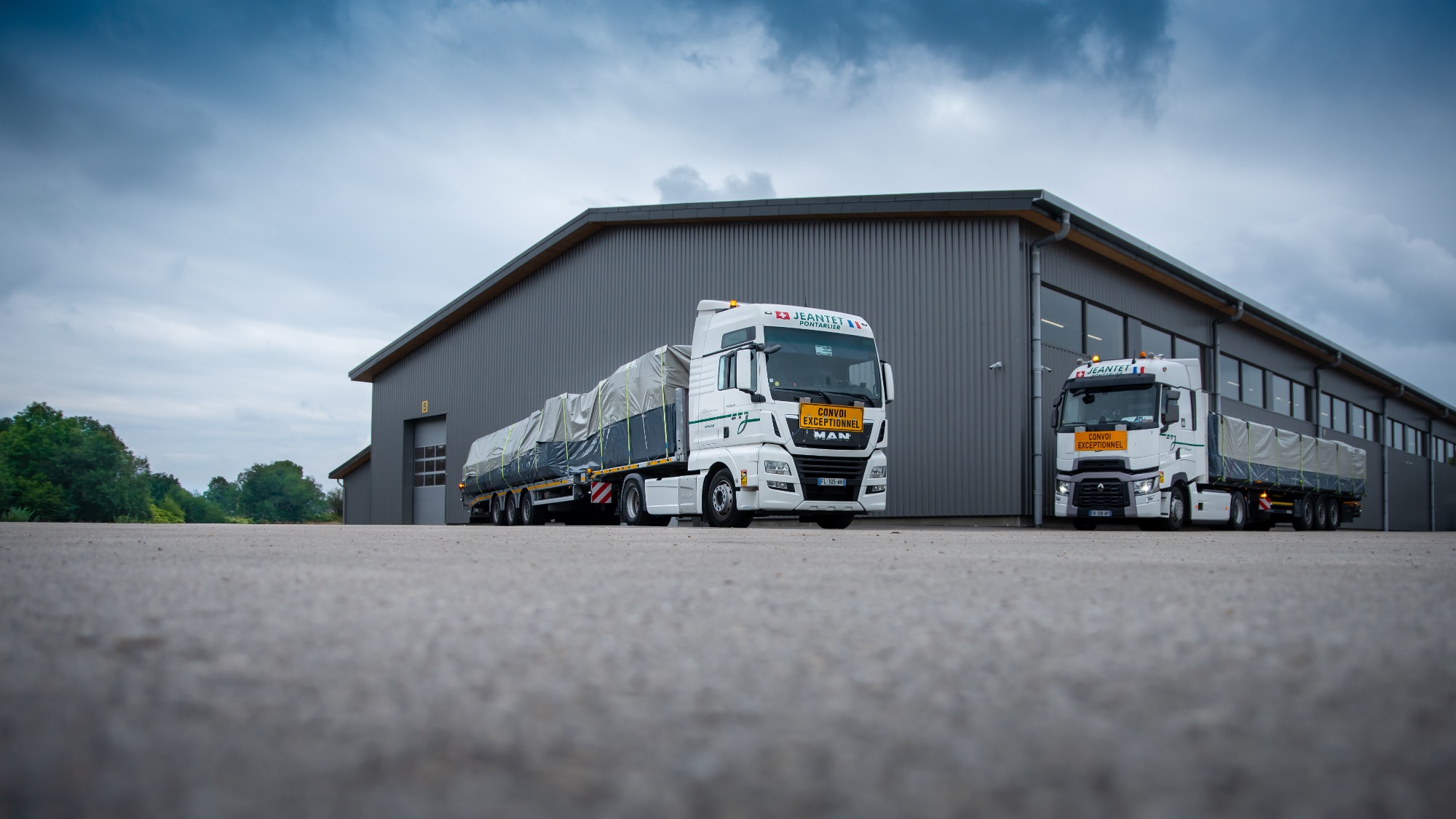 Camions professionnels stationnés devant un bâtiment industriel