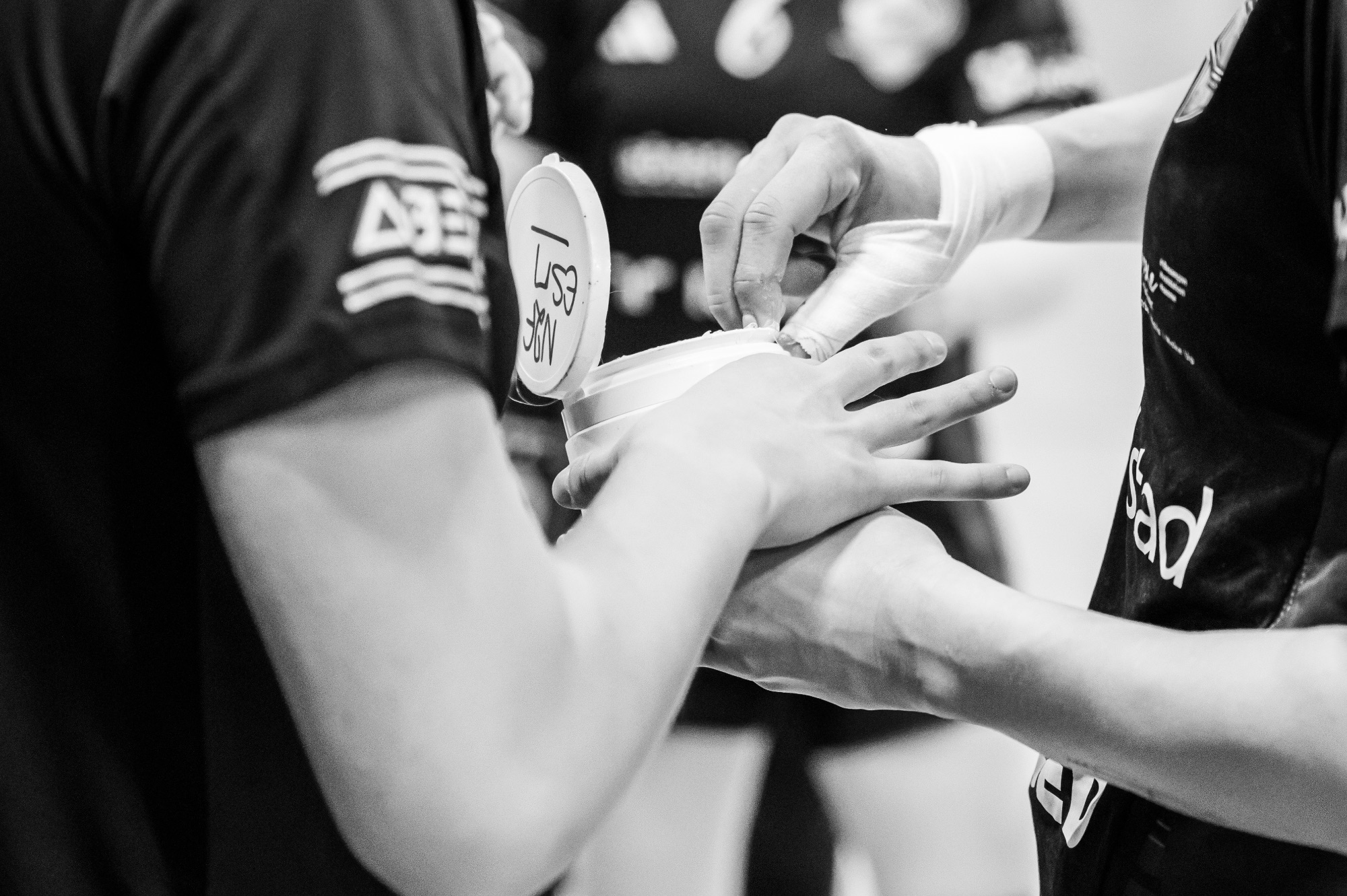 Deux mains préparant un équipement sportif avant un match.