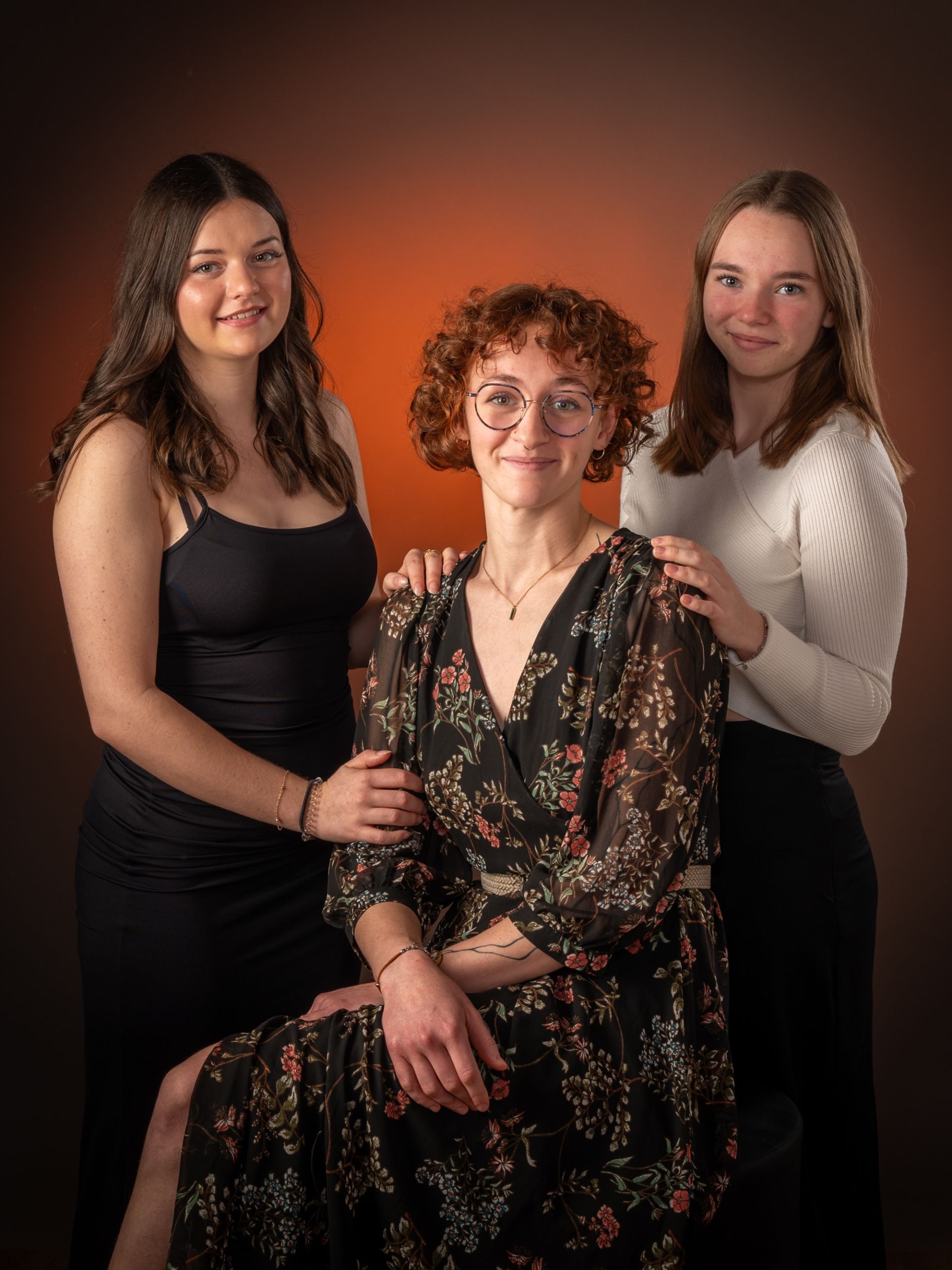 Séance photo en studio d'une famille avec trois femmes souriantes.