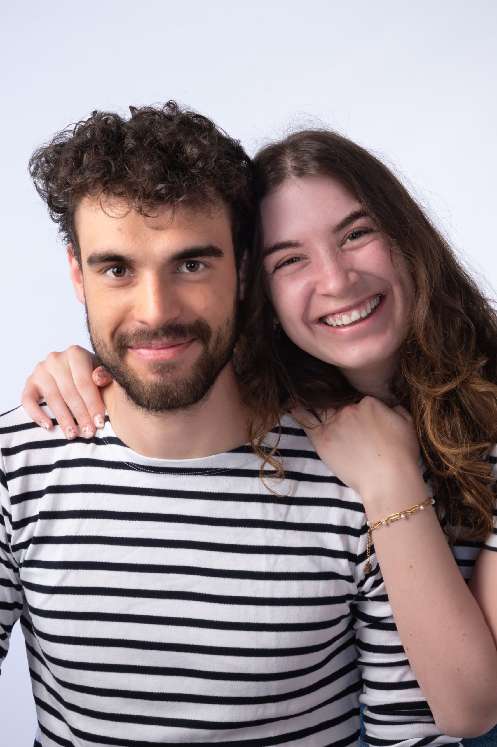 Portrait d'une famille souriante en studio, ambiance chaleureuse.