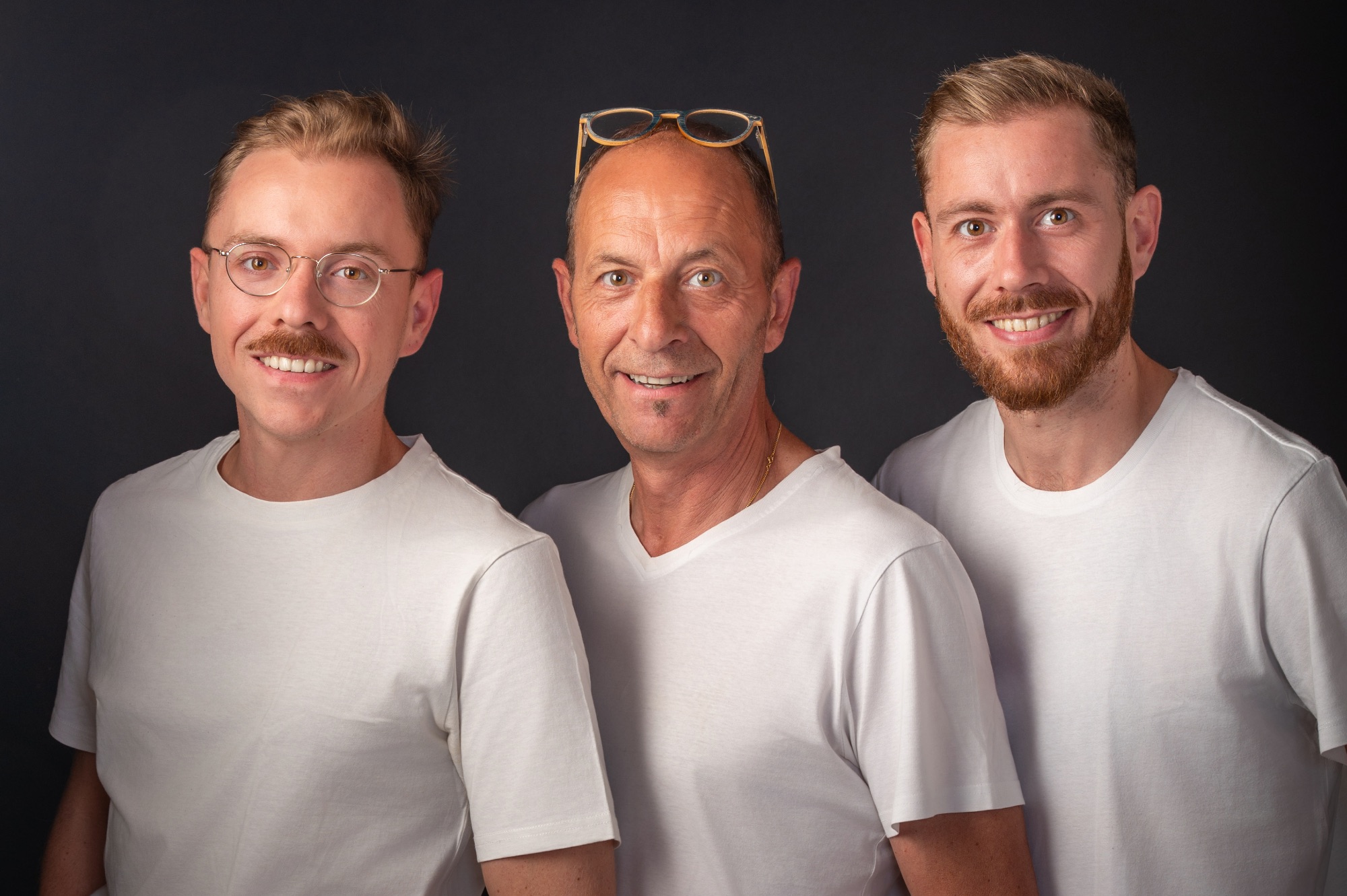 Portrait de famille en studio avec trois hommes souriants
