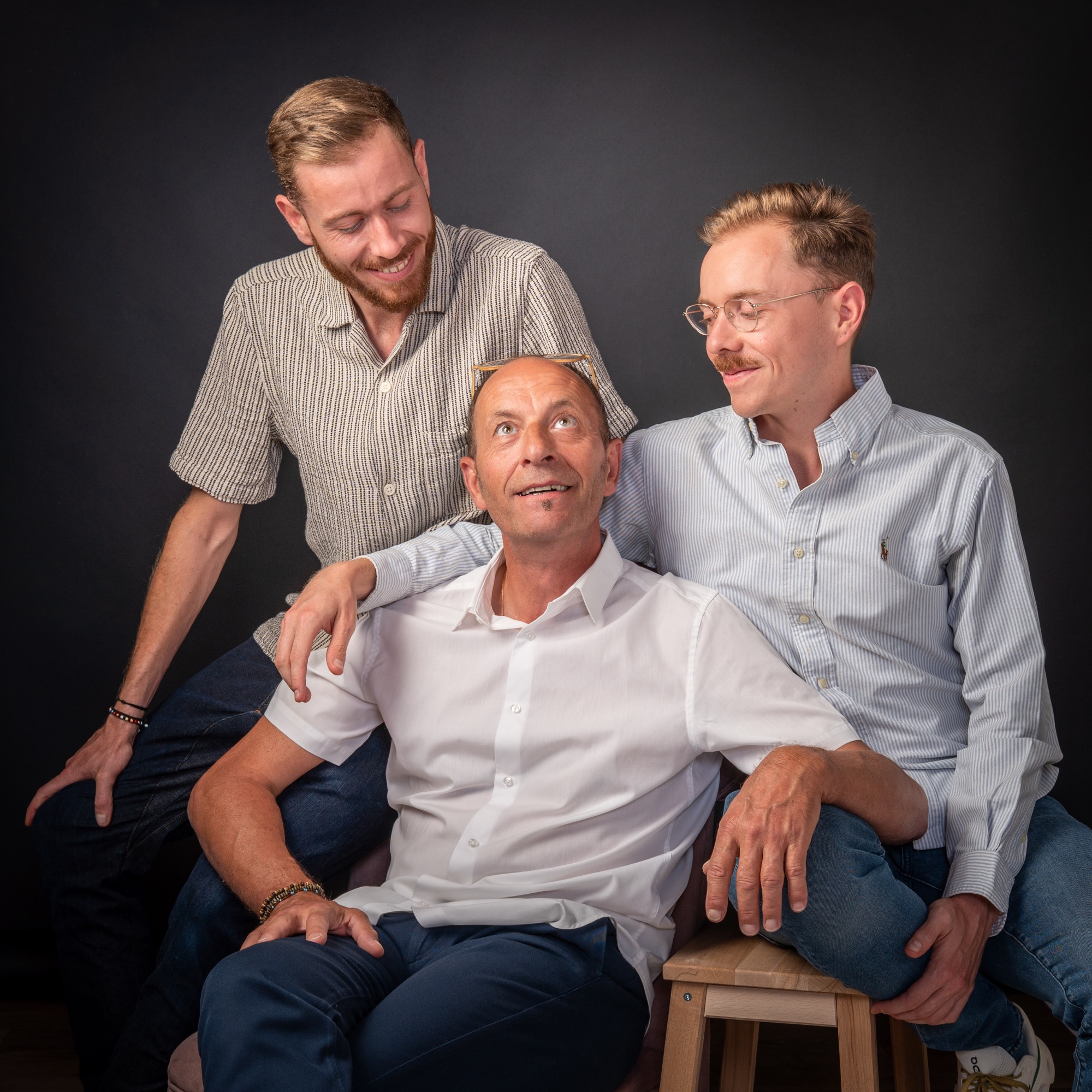 Portrait de famille en studio avec trois hommes souriants