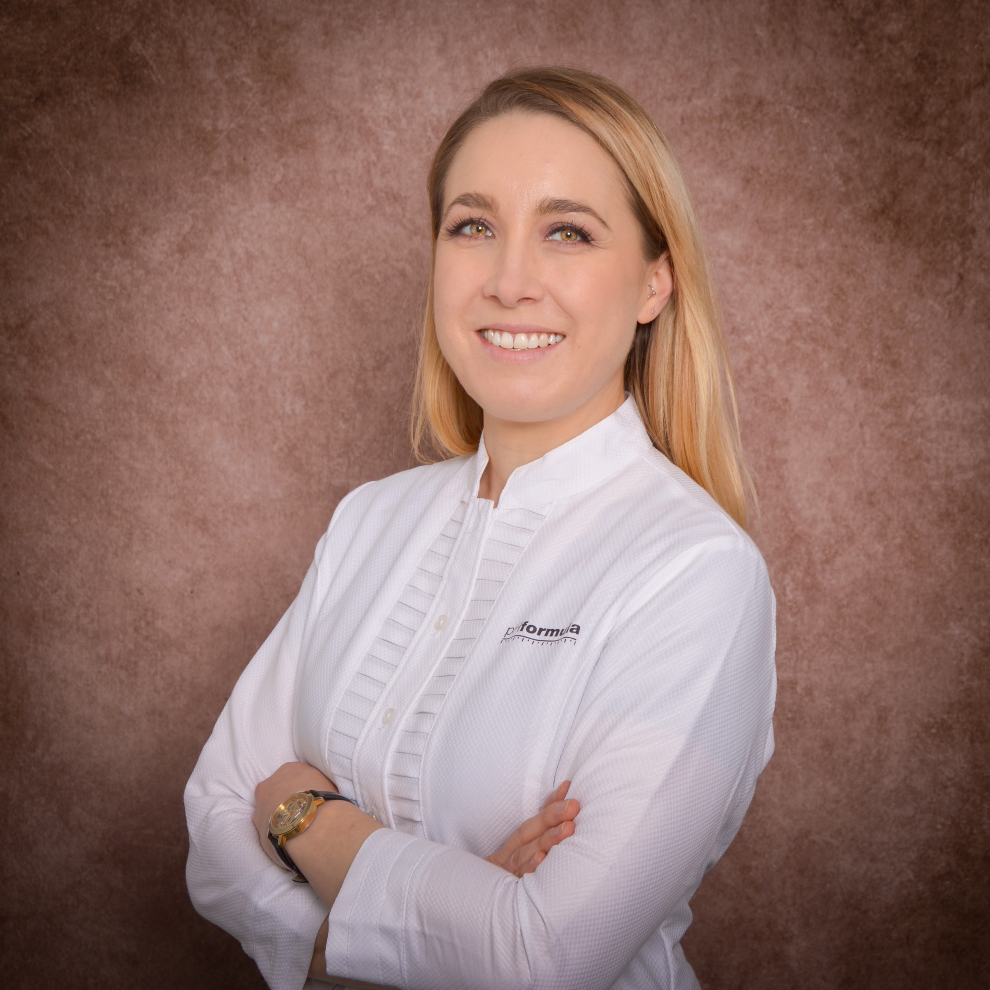 Portrait professionnel d'une femme en blouse blanche, souriante.