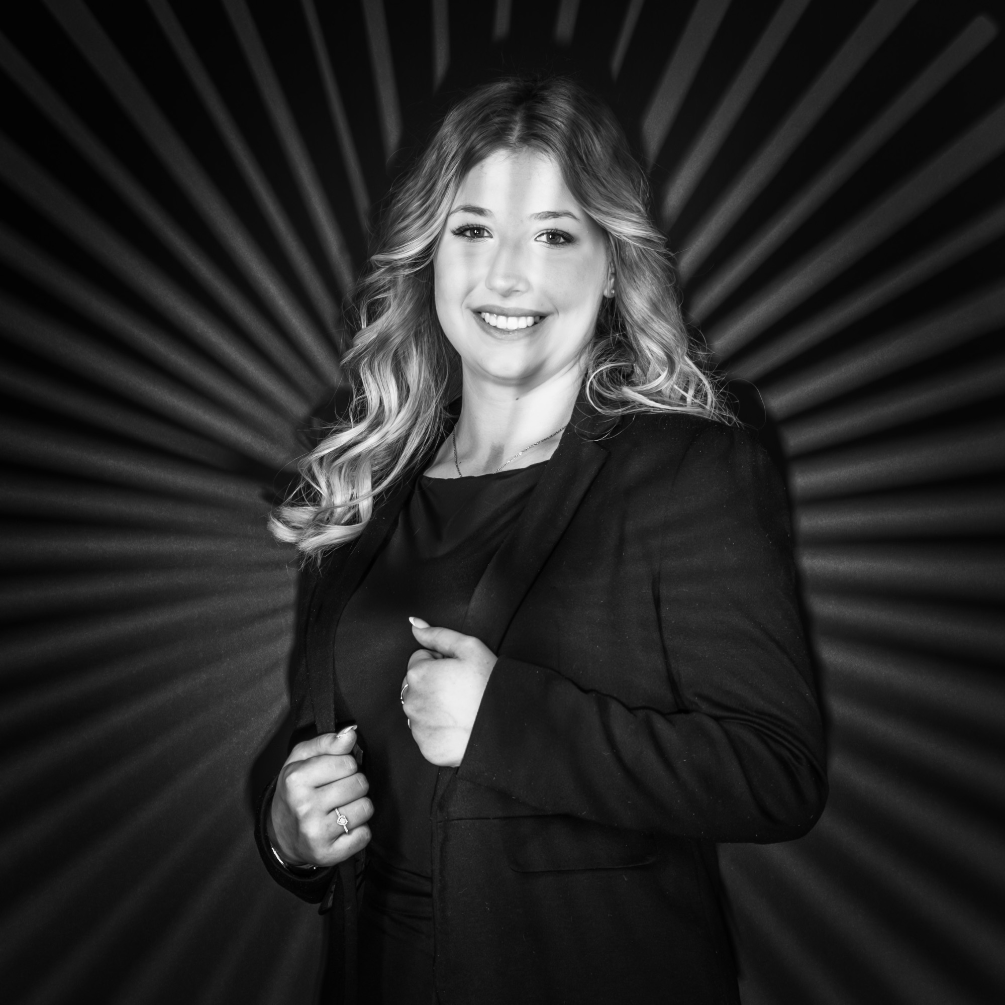 Portrait en noir et blanc d'une femme souriante en costume