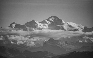 Montagnes enneigées avec nuages en arrière-plan en noir et blanc