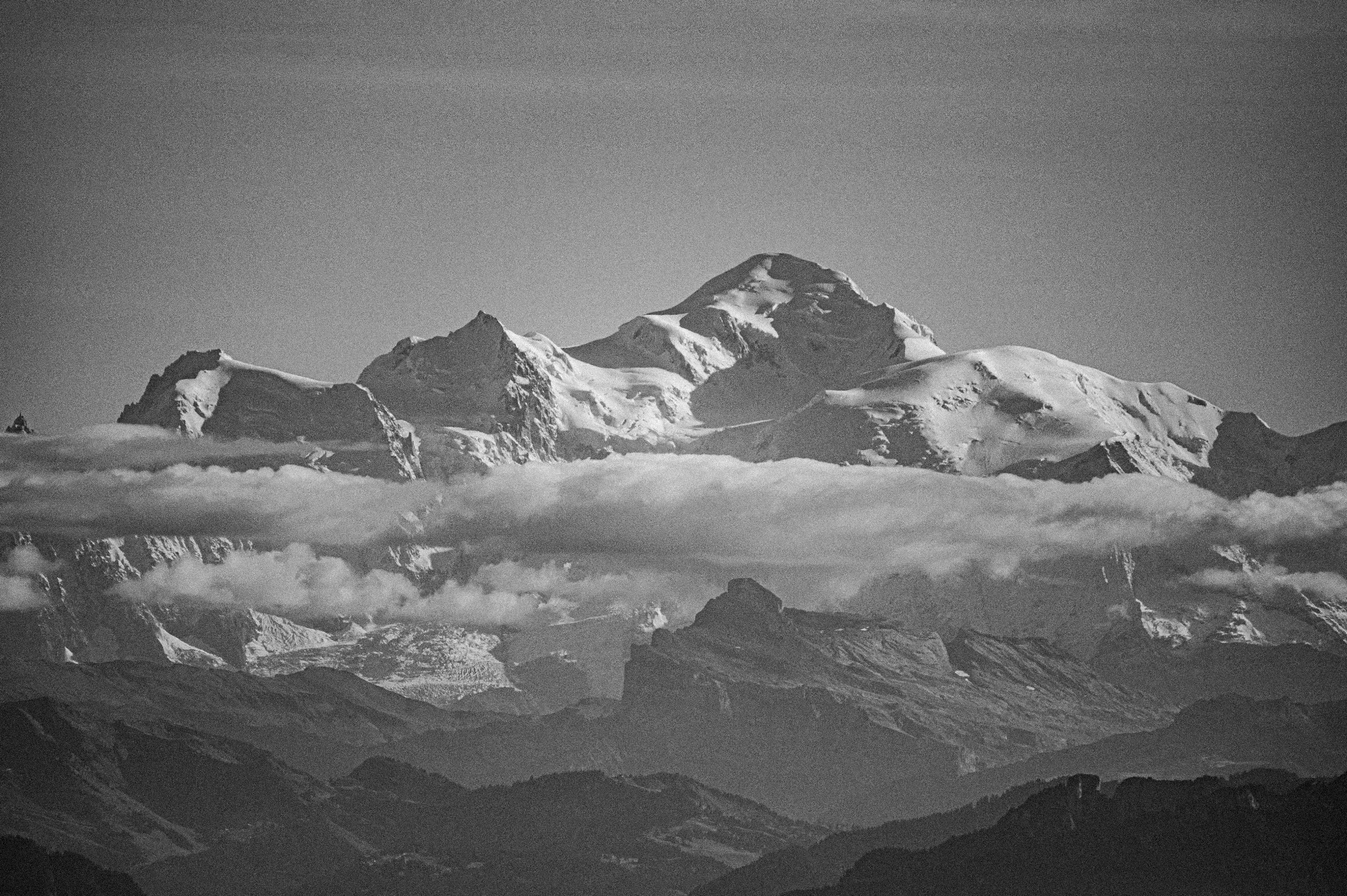 Montagnes enneigées avec nuages en arrière-plan en noir et blanc