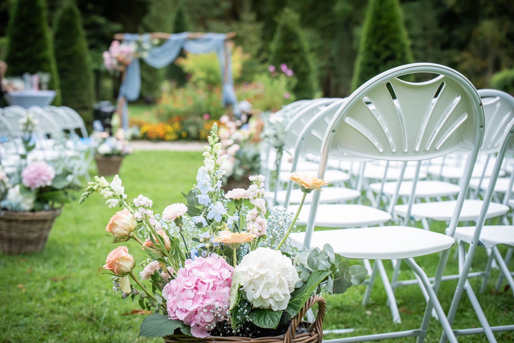 Décoration florale pour un mariage en extérieur avec chaises blanches