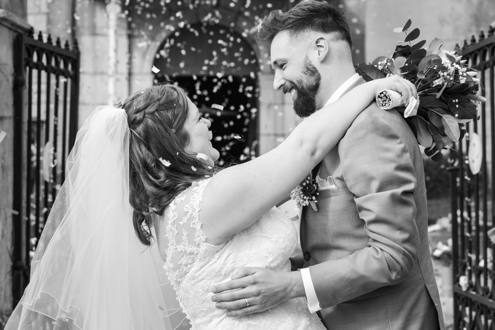 Couple heureux célébrant leur mariage sous une pluie de pétales.