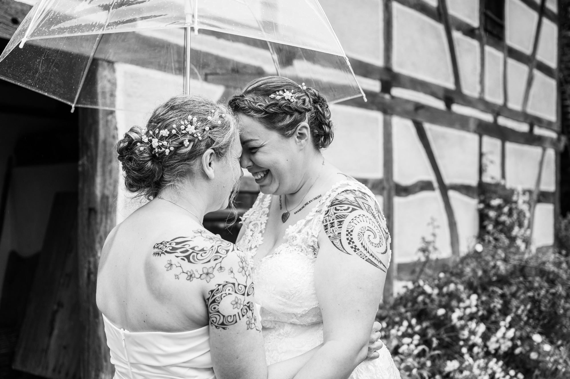 Deux mariées s'échangeant un regard complice en extérieur.