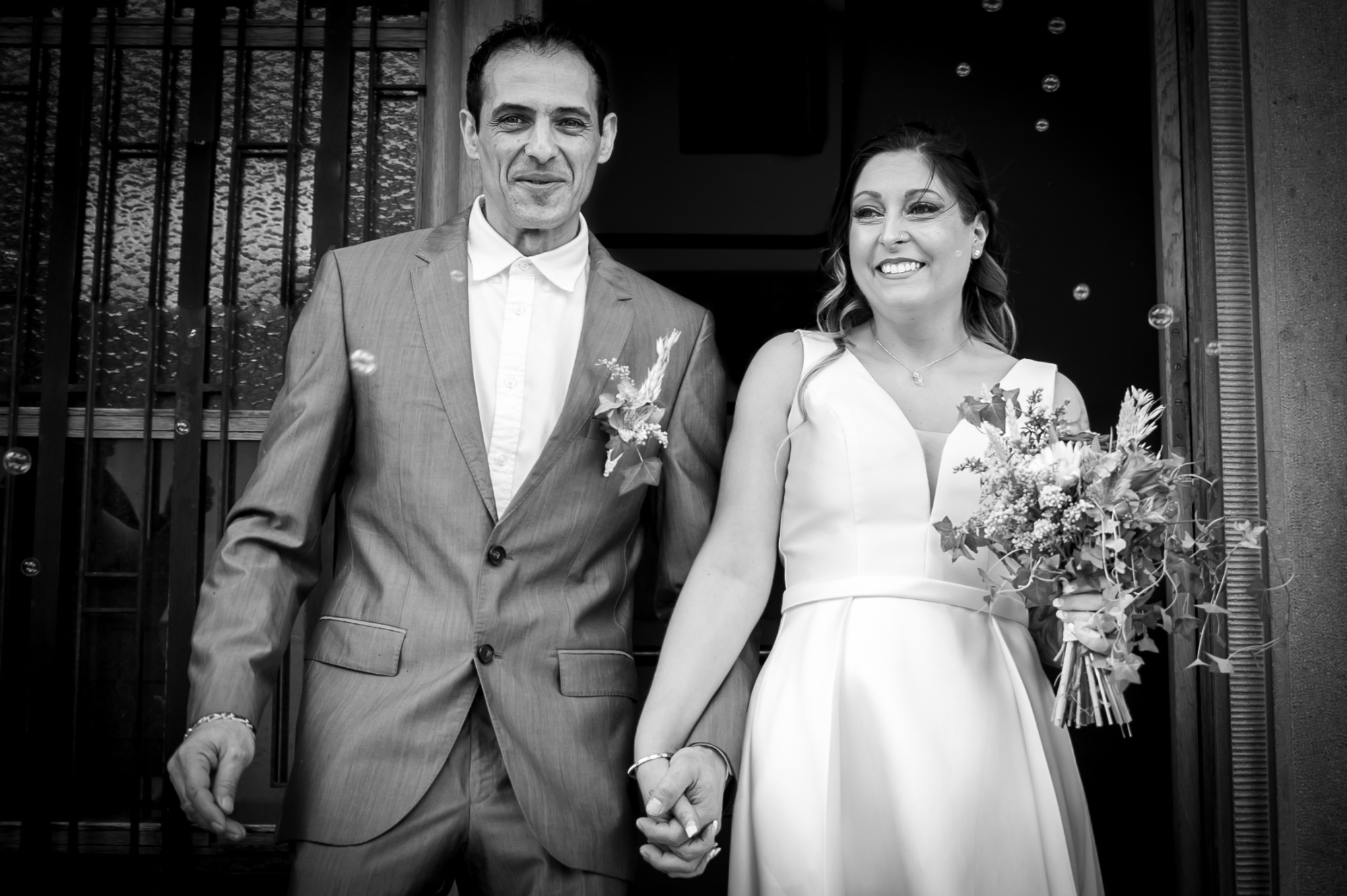 Couple heureux sortant de la cérémonie de mariage, main dans la main.