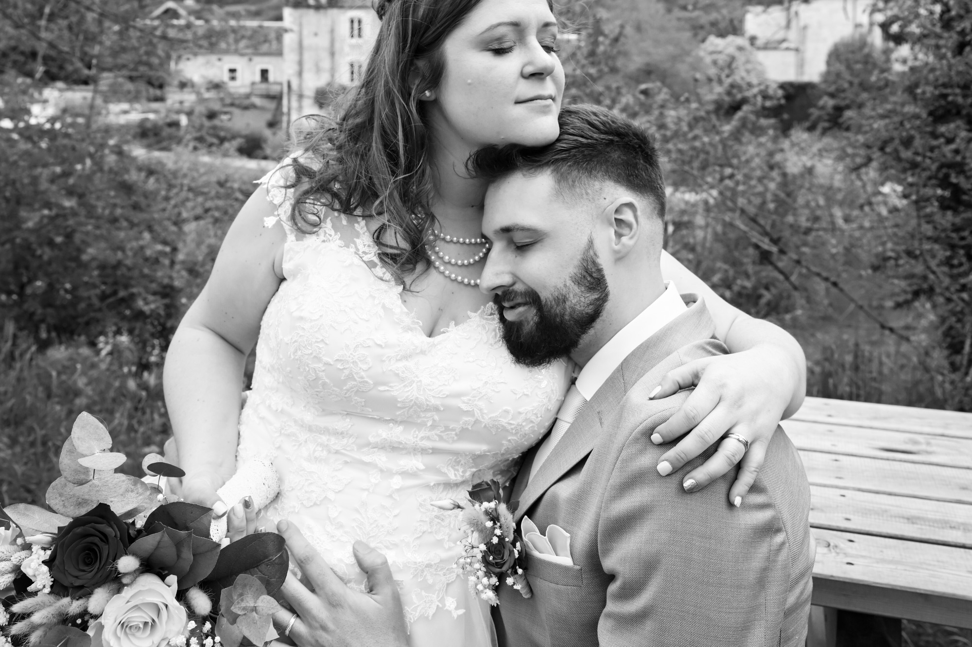 Couple de mariés en extérieur, moment tendre et romantique.