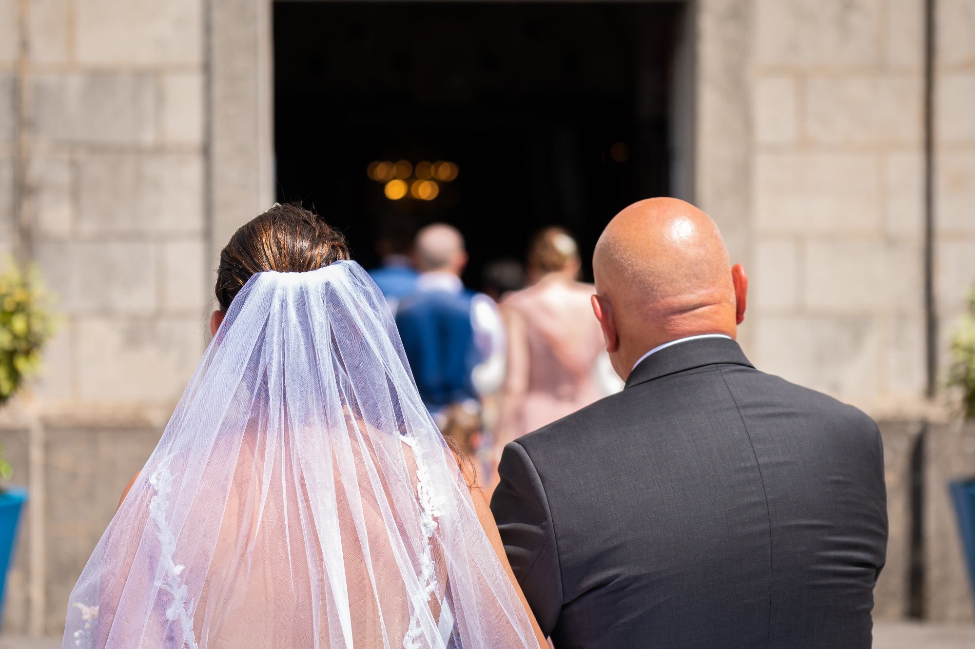 Couple de mariés regardant l'entrée de l'église lors de leur cérémonie.