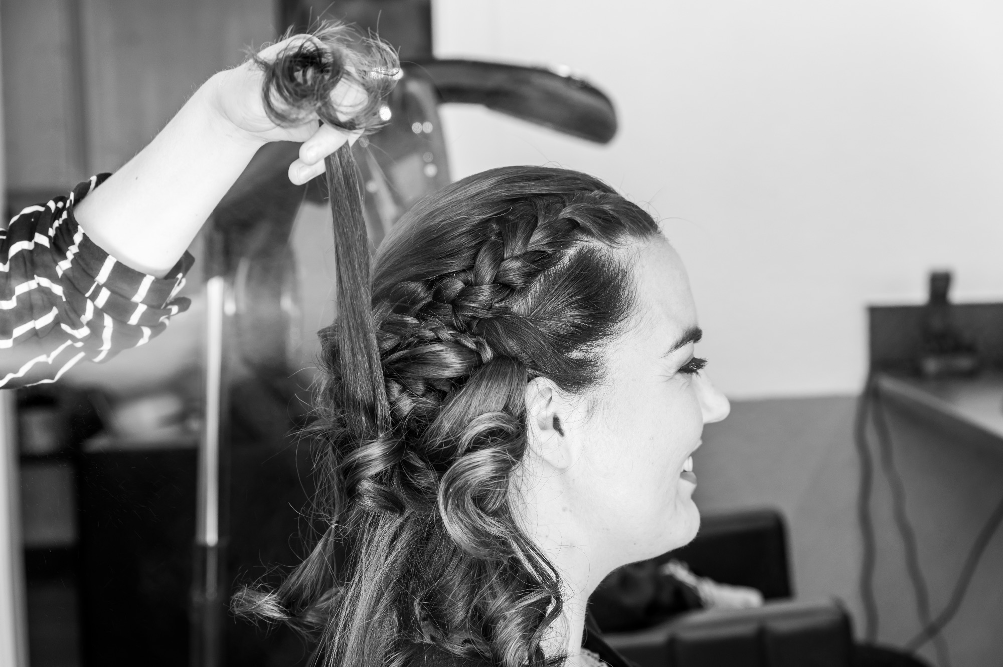Femme souriante avec coiffure élaborée lors d'un mariage.