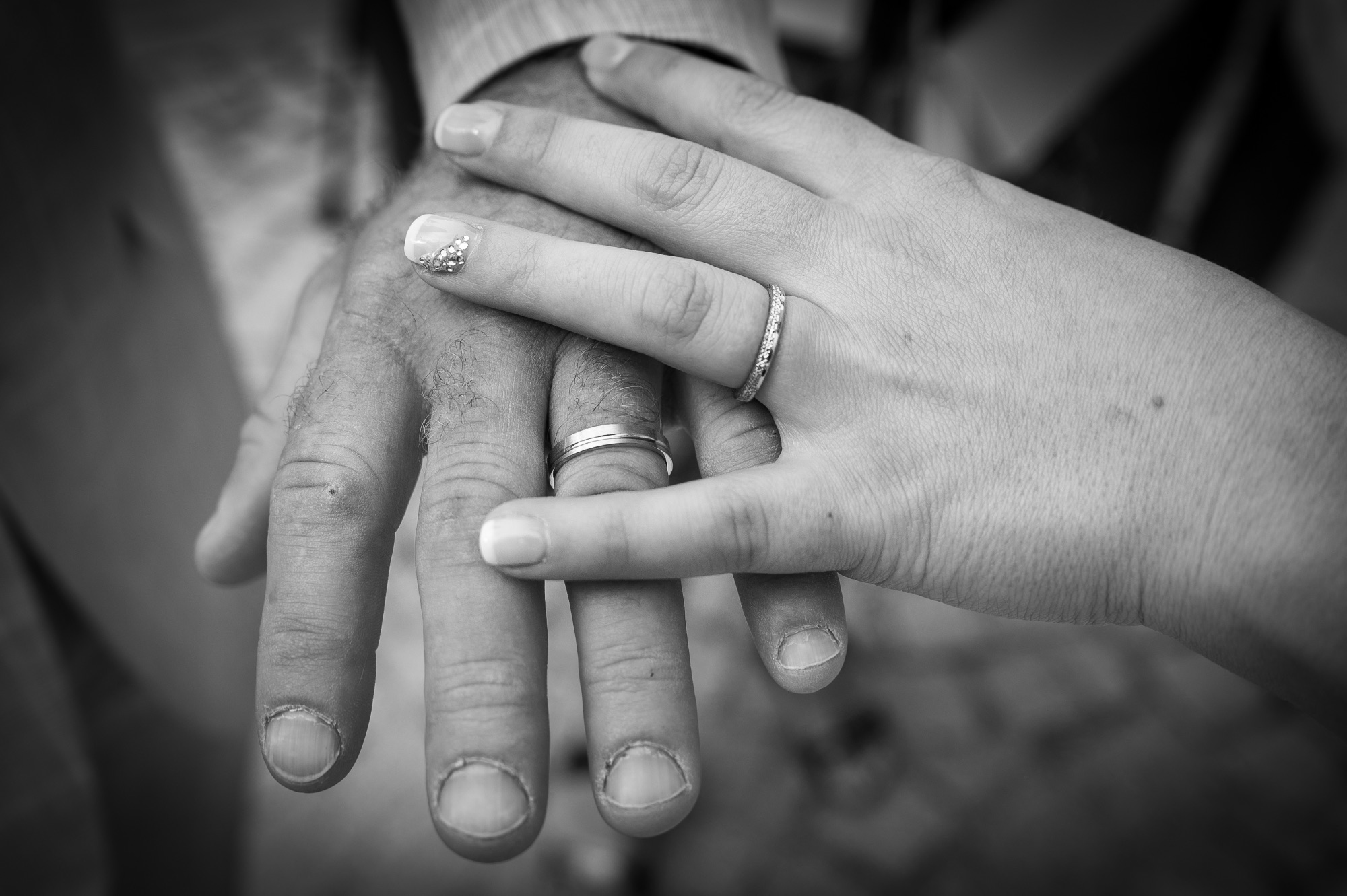 Mains entrelacées avec alliances, symbole d'amour et d'engagement.
